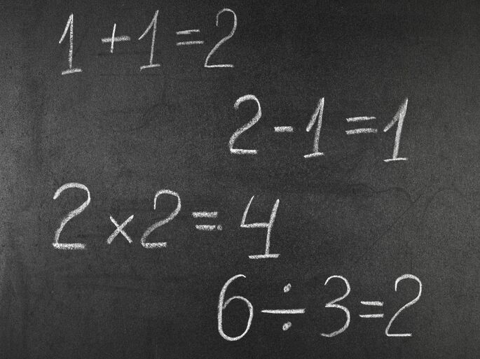 Ejemplos de aritmética sobre una pizarra: una suma, una resta, una multiplicación y una división