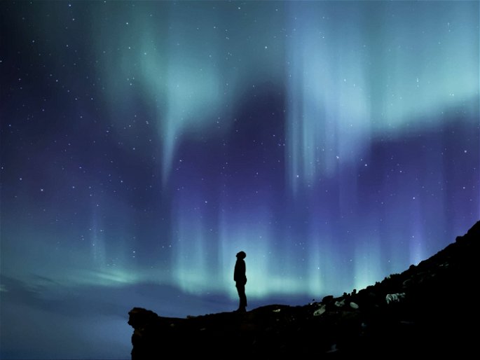 aurora boreal y persona mirando al firmamento