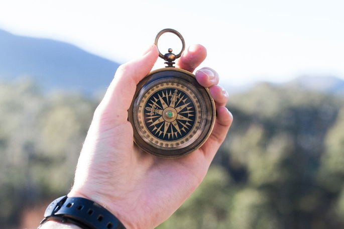 Mano sosteniendo una brújula