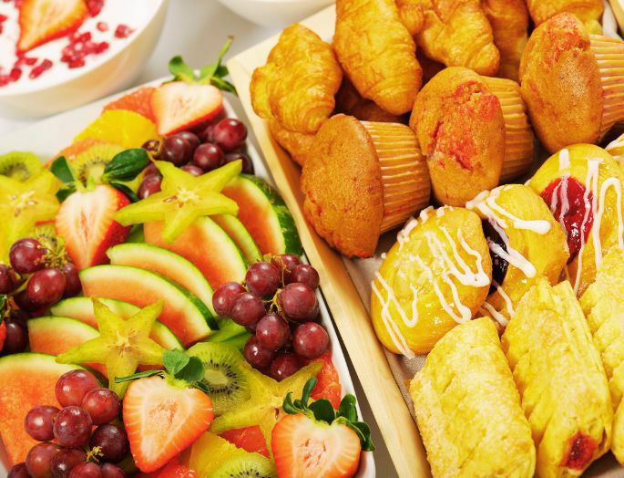 buffet con alimentos de desayuno (frutas y bollería)