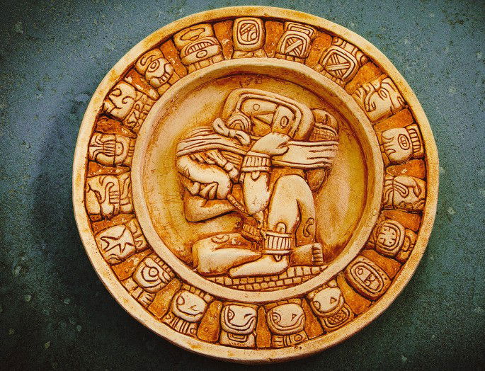 Representación del calendario maya (piedra circular sobre fondo gris)