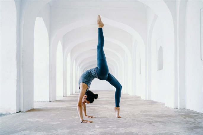Una mujer vestida de azul haciendo una pose de yoga.