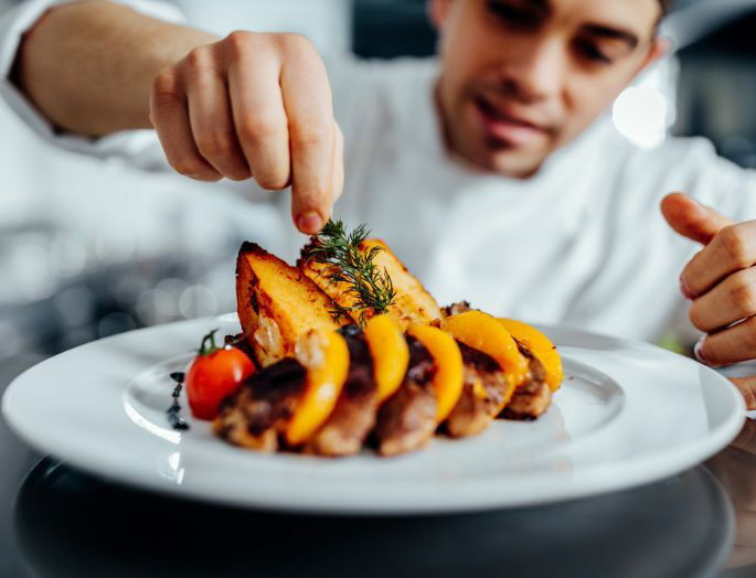 Chef decorando un plato de cocina profesional