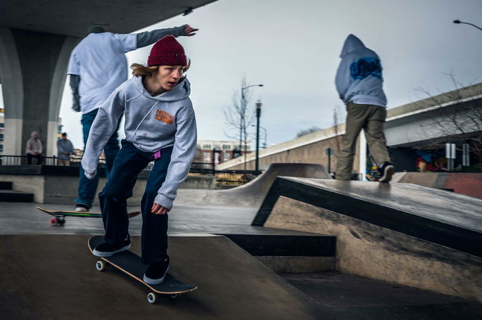Tres patinadores patinando en un parque de patinaje, un ejemplo de personas capaces de mantener su equilibrio dinámico.