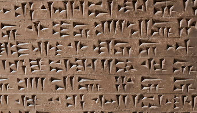 Escritura cuneiforme en tablilla de arcilla marrón