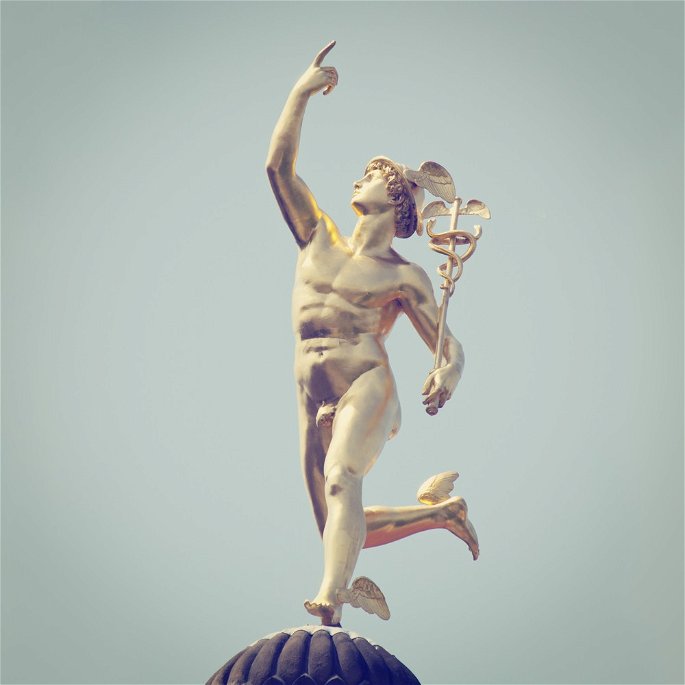 Escultura de bronce del dios Hermes sobre fondo azul