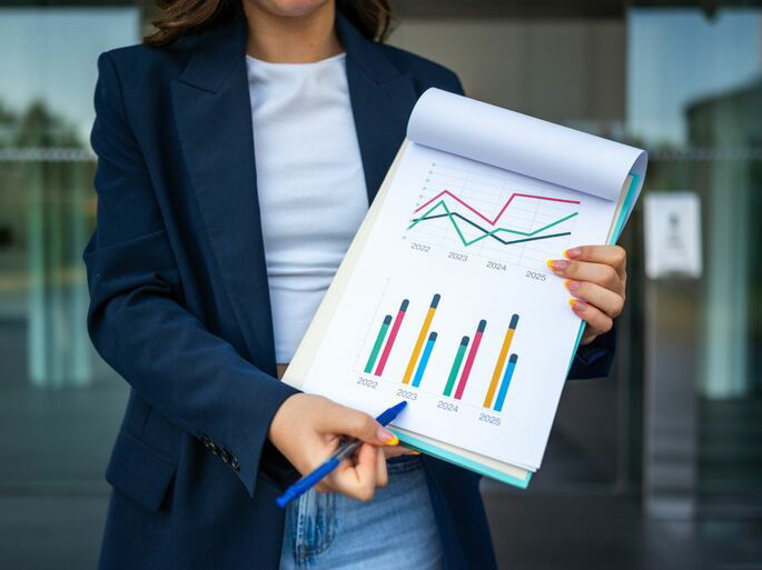 Una mujer mostrando las estadísticas de varios años en su oficina, explicando sus conclusiones