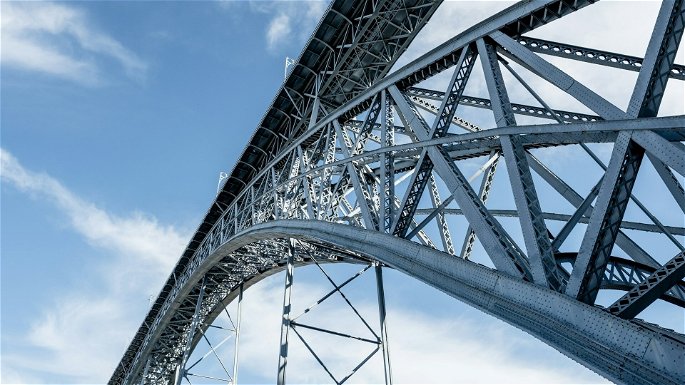 La estructura de un puente, hecha de acero, durante el día bajo un cielo casi despejado.