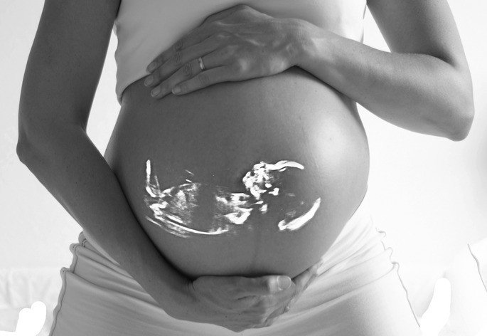 montaje de una ecografía sobre el abdomen de una mujer embarazda-etapas del desarrollo humano