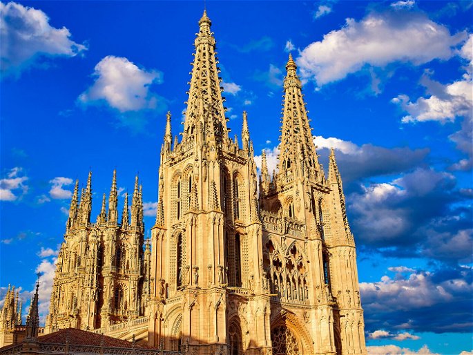 Fachada de la catedral de Burgos sobre cielo azul con nubes