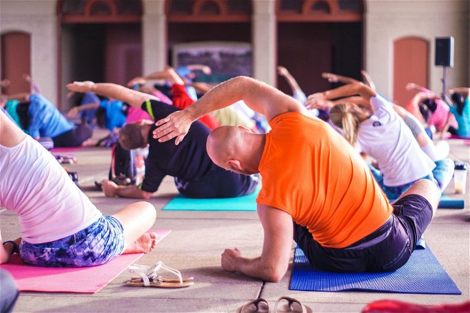 Un grupo de personas realizando una clase de yoga, mejorando la flexibilidad física y reduciendo el estrés.