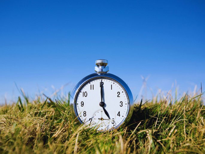 Reloj al aire libre sobre un campo de hierba