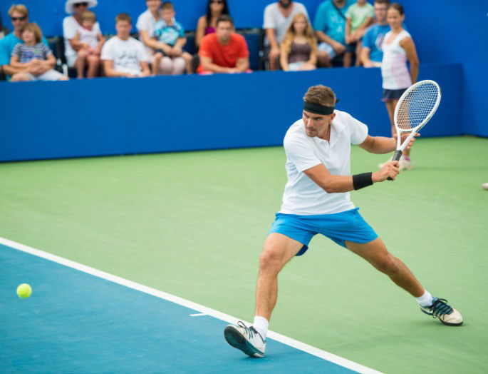 Jugador de tenis a punto de recibir la bola con la raqueta