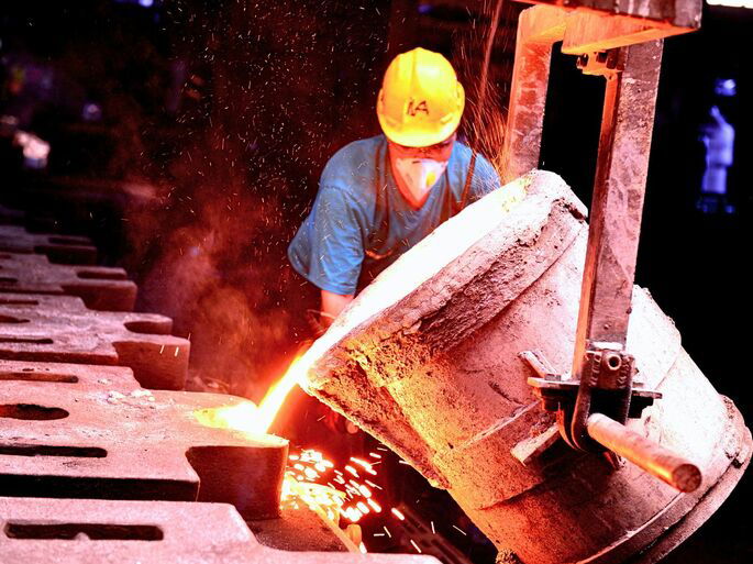 Un obrero supervisando el tratamiento de un metal en una fábrica de metalurgia