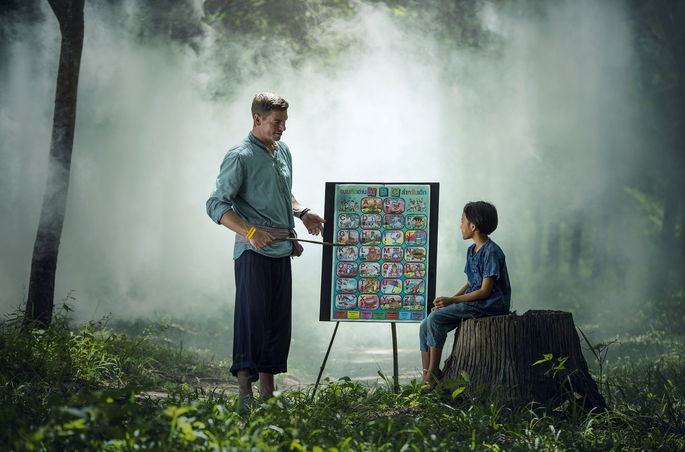 hombre dando una clase a un niño en mitad del bosque