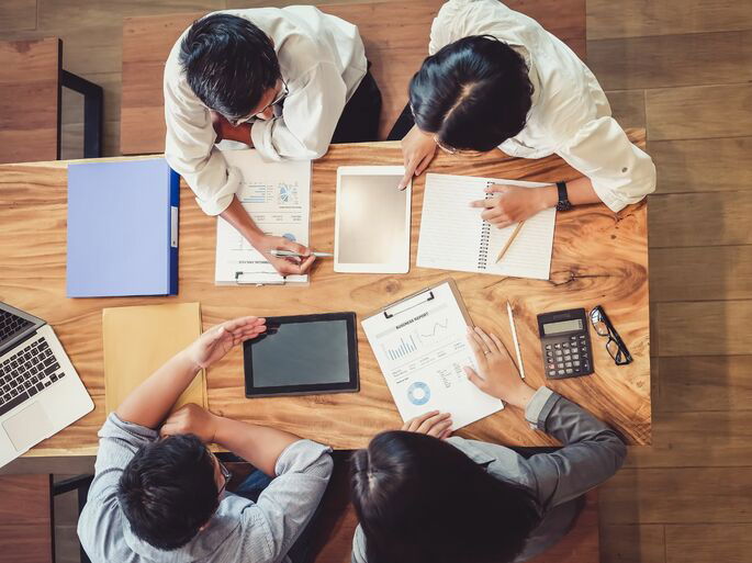 Un grupo de cuatro personas revisando información relevante de la compañía