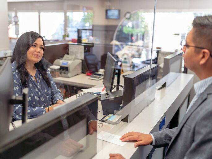 Una empleada de un banco atendiendo a un cliente