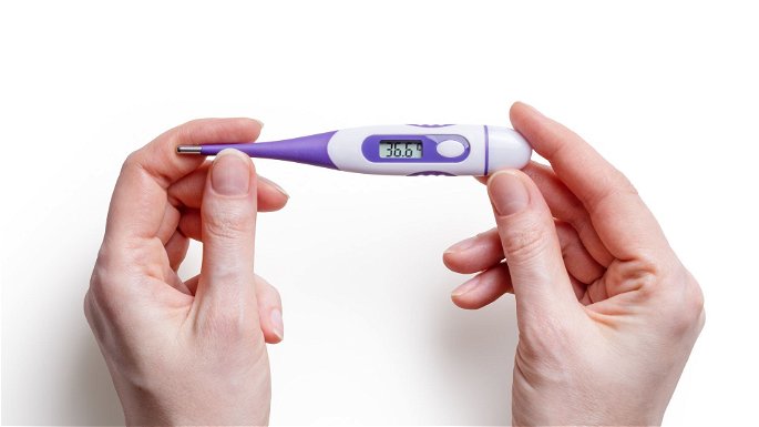Un termómetro digital calculando la temperatura corporal de una persona